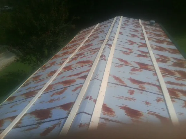 Rusted metal roof panels with new wood purlins before replacement — Storm Damage Roof Repair in Ballico by Roofing Brothers