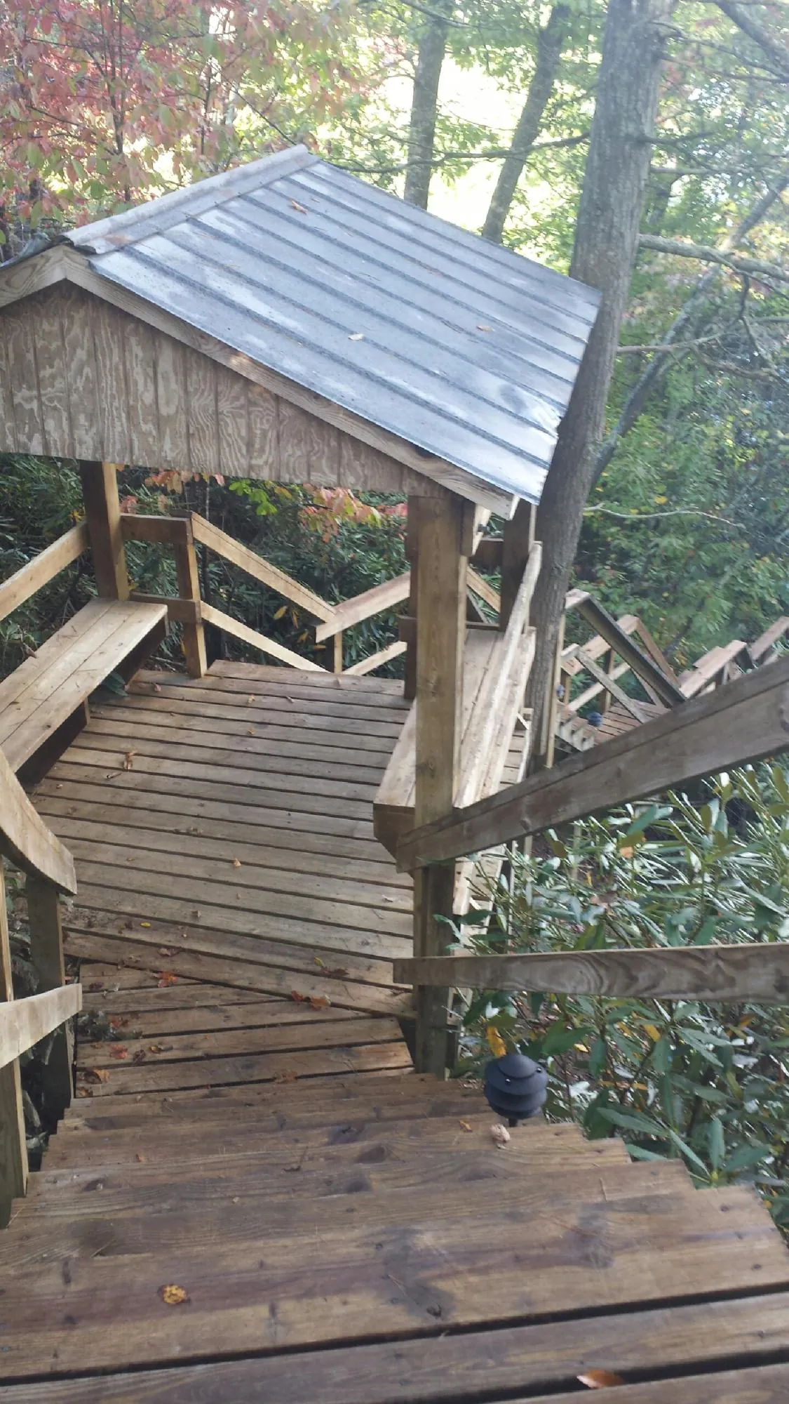 Metal roofed shelter over wooden steps on a wooded walkway — Skylight Repair & Installation work by our crew in Ballico